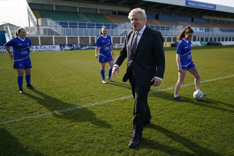 Britain's Prime Minister Boris Johnson speaks with players from the women's team during a visit to Hartlepool United Football Club as he campaigns on behalf of Conservative Party candidate Jill Mortimer in Hartlepool, north-east England on April 23, 2021, ahead of the 2021 Hartlepool by-election to be held on May 6.