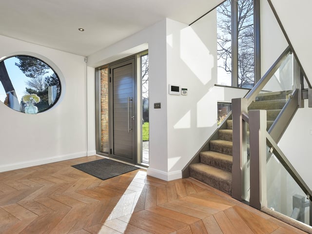 Entering the house you are greeted by a spacious entrance hall with glass balustrade staircase and three storey height feature window.