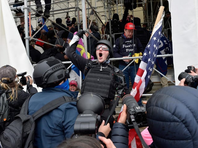 A man calls on people to raid the building as Trump supporters clash with police and security forces as they try to storm the US Capitol in Washington D.C on January 6, 2021. - Demonstrators breeched security and entered the Capitol as Congress debated the a 2020 presidential election Electoral Vote Certification. (Photo by Joseph Prezioso / AFP)