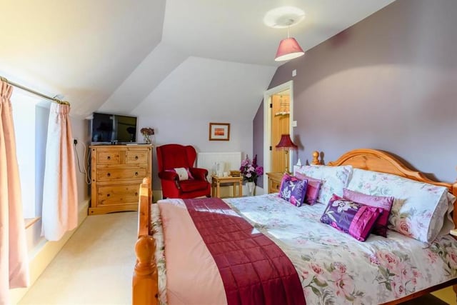 We're moving up to the second floor now, and into another double bedroom. Bright and light, thanks again to double-glazed windows offering lovely views, it features an exposed stone wall and its own en suite shower room.