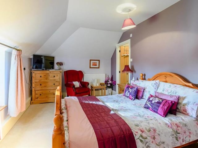 We're moving up to the second floor now, and into another double bedroom. Bright and light, thanks again to double-glazed windows offering lovely views, it features an exposed stone wall and its own en suite shower room.