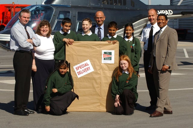 Pupils from Fir Vale School pick up the new sign for the school showing its new business and enterprise status in a ceremony at Sheffield City Airport