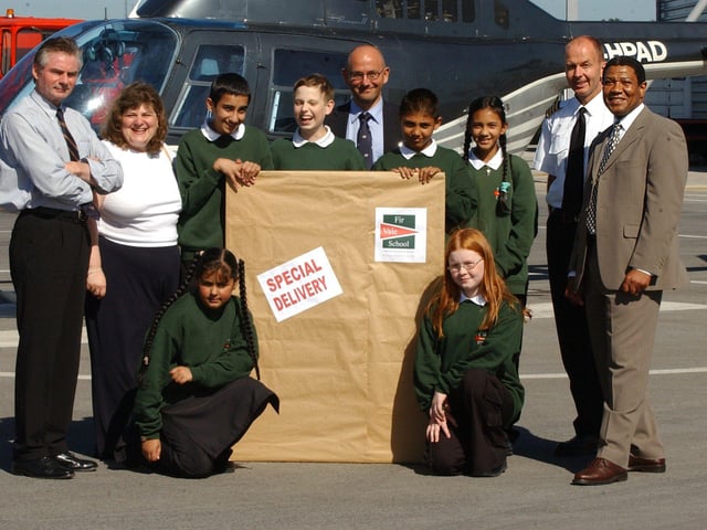 Pupils from Fir Vale School pick up the new sign for the school showing its new business and enterprise status in a ceremony at Sheffield City Airport