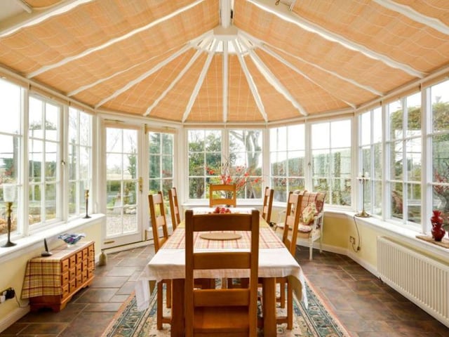 Double doors from the kitchen lead into the Mozolowski and Murray conservatory, which is currently being used as a dining room, and overlooks the magnificent gardens