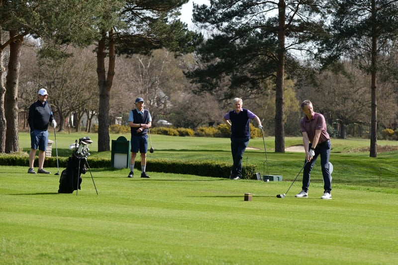Golfers are pictured on the course.