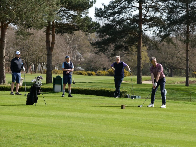 Golfers are pictured on the course.
