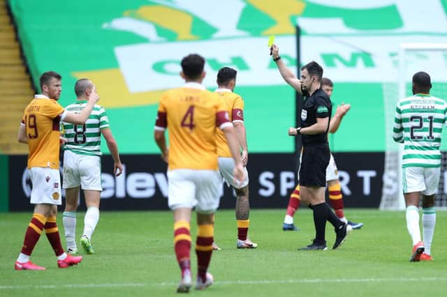 Referee Don Robertson awards a yellow card. (Photo by Ian MacNicol/Getty Images)