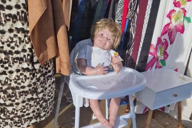 The doll has appeared in the window strapped into a pram or in a high chair, and reduced from £60 down to £40. It does not seem to have any takers so far (Char Myers-Abdulazeez)