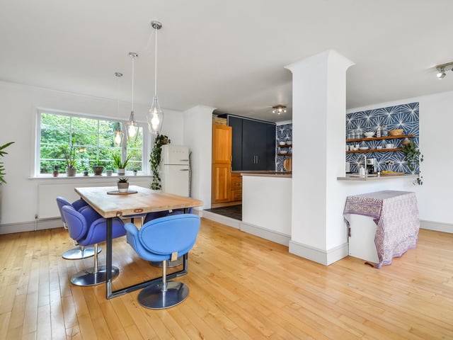 There is a step leading up to the kitchen area with breakfast bar to one end