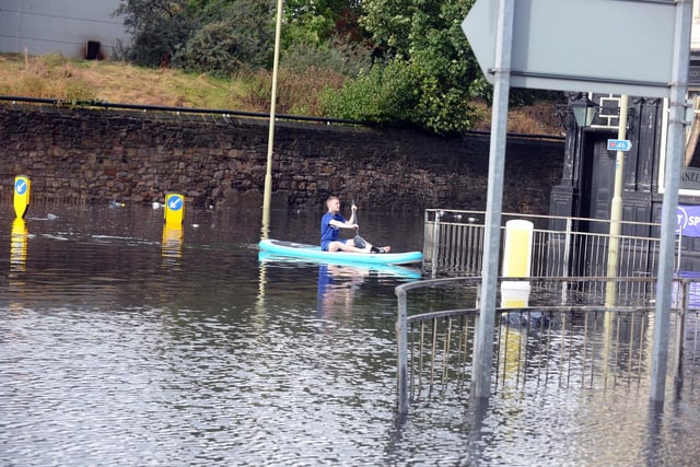 A paddle boarder takes to the floodwaters