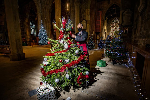 Canon Geoffrey Harboard trims a tree in Sheffield Cathedral for the Christmas Tree Festival in December 2020