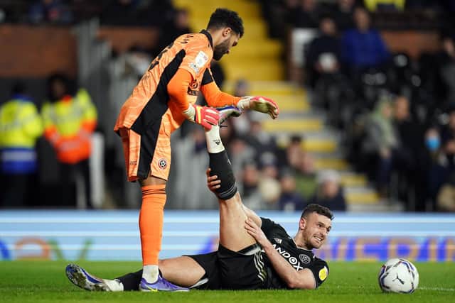 Sheffield United's Wes Foderingham helps Jack Robinson with cramp on the defender's first appearance for three months at Fulham: Adam Davy/PA Wire.