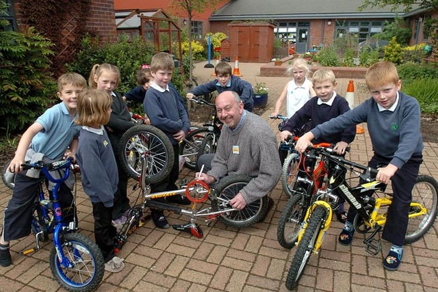 Pupils at Birley Spa Primary watch as John Sturdy from the South Yorks Neighbourhood Watch, puts a post code and house number on their bikes. This was just one of the events running as part of the school's Safety Week (May 2004)