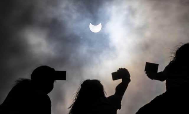 Partial solar eclipse watched by people through welders glass on Arthur's Seat in Edinburgh picture: Katielee Arrowsmith SWNS