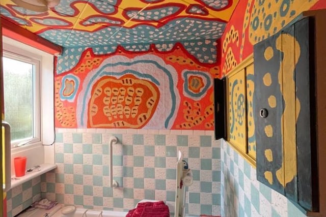The bathroom also has brightly coloured walls.