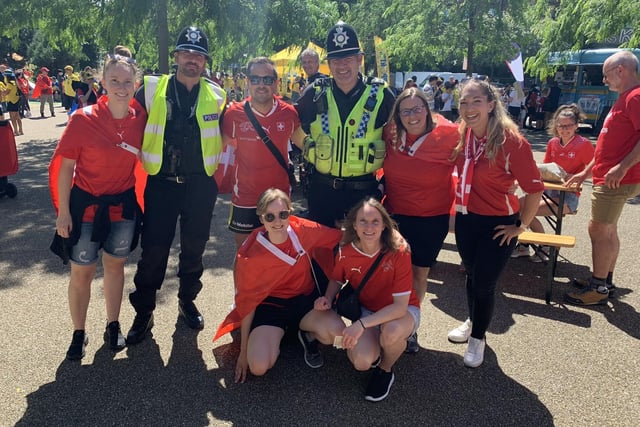 Switzerland fans pose for pictures with police officers near the Sheffield Fan Zone