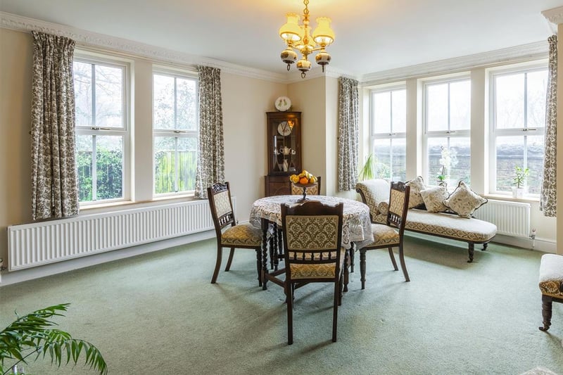 With carpet to flooring, central heating radiator, feature fireplace with surround and dual-aspect windows to the front and side elevation.