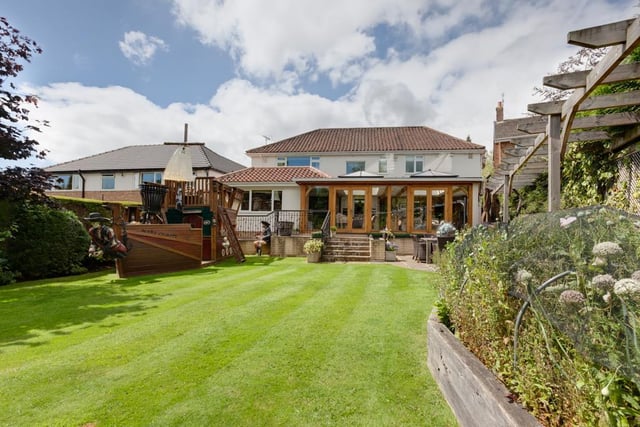 The property is set far back from the road within a plot that extends to approximately a third of an acre, with a generously sized rear garden with lawns, mature trees, shrub borders, two summerhouses - and the pirate ship, seen here on the left.