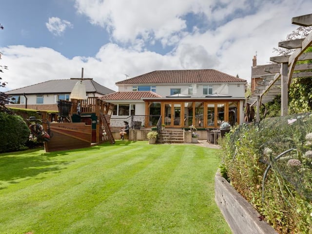 The property is set far back from the road within a plot that extends to approximately a third of an acre, with a generously sized rear garden with lawns, mature trees, shrub borders, two summerhouses - and the pirate ship, seen here on the left.