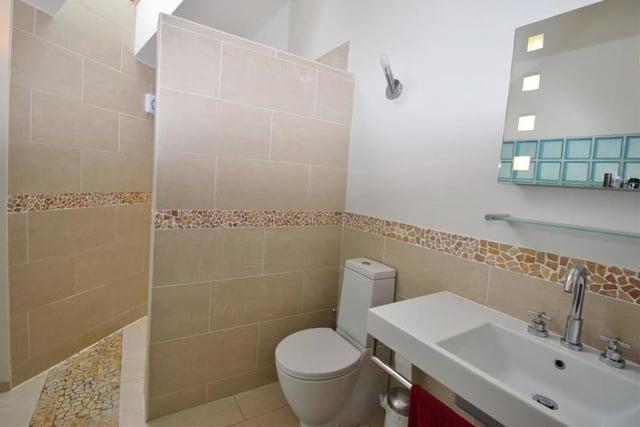 The en suite to the master bedroom comprises a modern wet room with a walk-in shower, wash hand basin and low-flush WC. There's also a feature glass block wall, back-lit mirror, heated towel-rail and tiled floor.