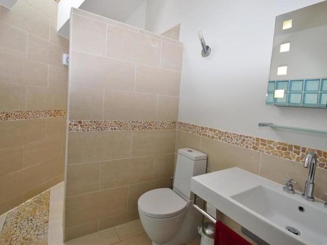 The en suite to the master bedroom comprises a modern wet room with a walk-in shower, wash hand basin and low-flush WC. There's also a feature glass block wall, back-lit mirror, heated towel-rail and tiled floor.