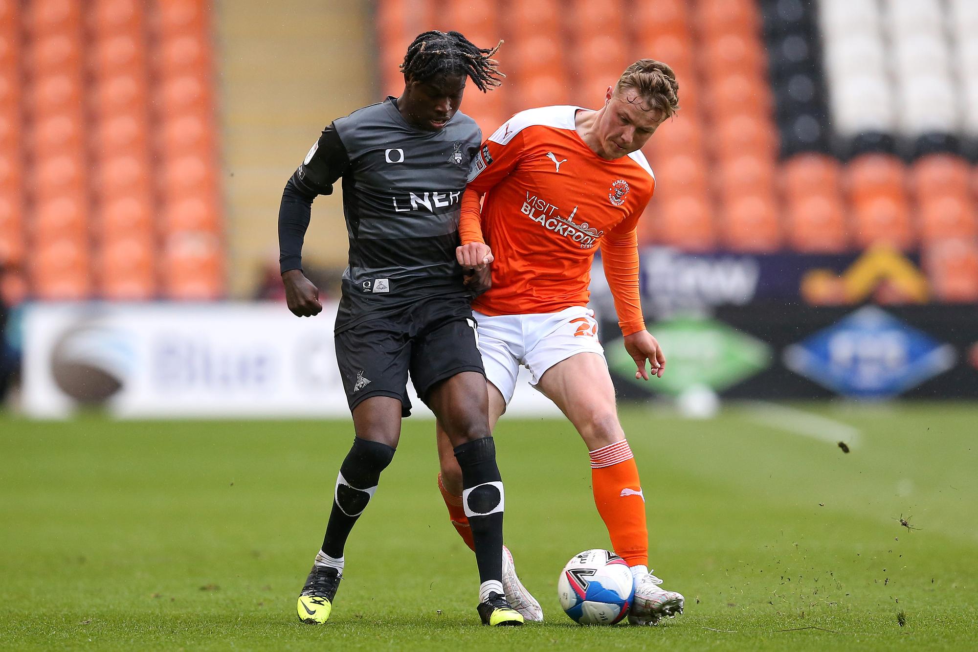 Taylor Richards tussles with Blackpool's Dan Ballard