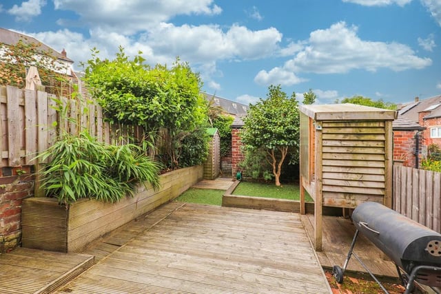 The garden features decking and greenery, making it an attractive space.