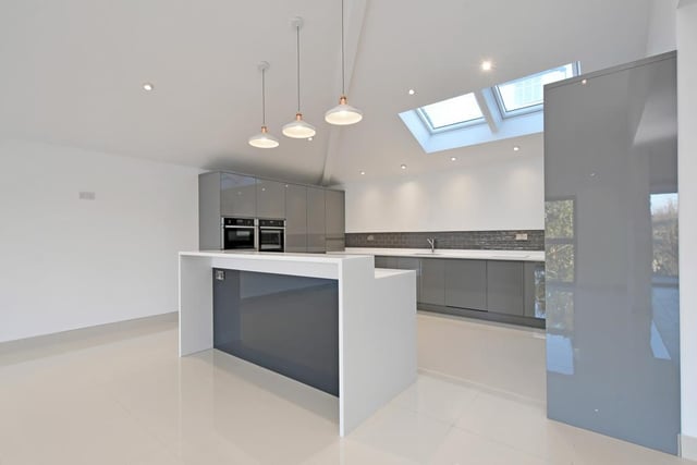 The dining kitchen has a range of fitted high gloss units with matching Corian work surface, a central island, Neff appliances, an integrated full-height Hoover fridge and freezer and a Caple wine cooler.