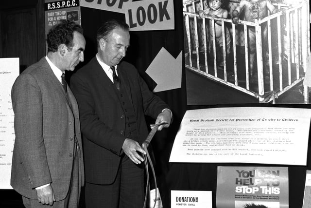 Lord Wheatley and Mr Alastair  Dunnett, editor of The Scotsman, discuss the 'Cruelty to Children' display in The Scotsman office in September 1965.