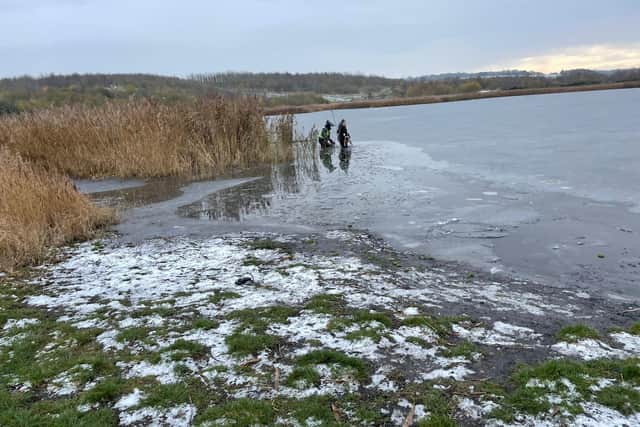 A woman's cries for help were heard by passing police officers after she entered a frozen lake to try to save her dog