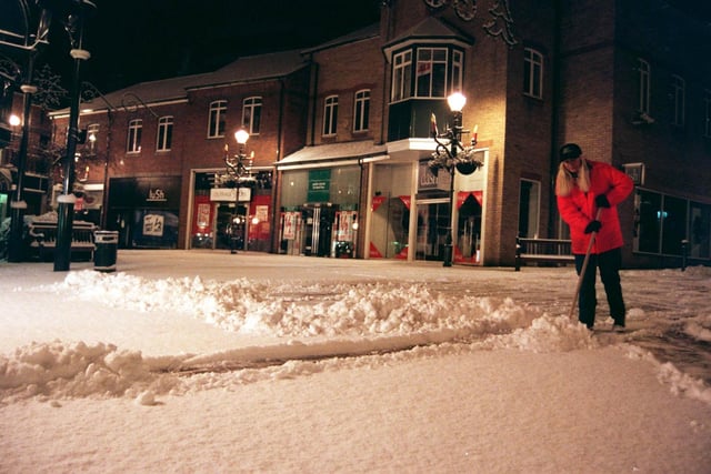 A sign of things to come?  Christine Marriott was up at first light clearing away the snow ready for shoppers at Orchard Square in December 1996