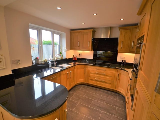A superb dining kitchen with open plan access to the orangery. The kitchen boasts a stylish range of Oak wall and base units, complemented with stunning gloss black granite work surfaces, incorporating a one and a half bowl with chrome mixer tap. Neff integrated double ovens, Neff induction hob with matching extractor fan hood and splash back wall plate. Fridge freezer, dishwasher, inset down lighting and under cupboard lighting. A upvc double glazed window provides a pleasant outlook to the rear garden This beautiful kitchen is also complemented with contrasting floor tiles and under floor heating which continues throughout this large open plan living area.