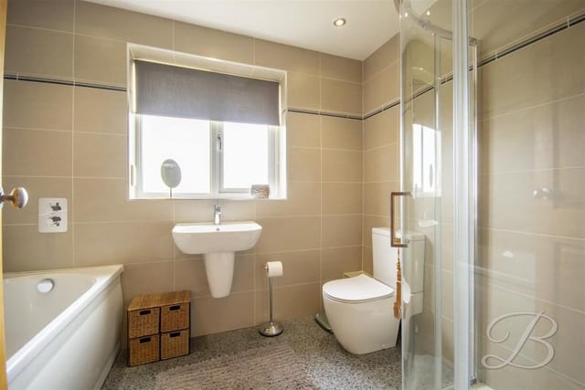 A "delightfully" well appointed family bathroom, fitted with a suite in white comprising; panelled bath, shower cubicle, low level WC and a wall mounted wash hand basin.