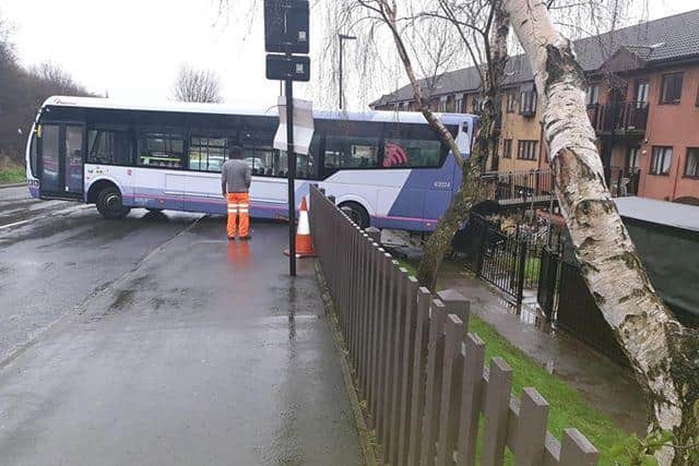 A bus has become wedged on Manor Oaks Road after it crashed through railings. Photo by Nathan Whittaker.