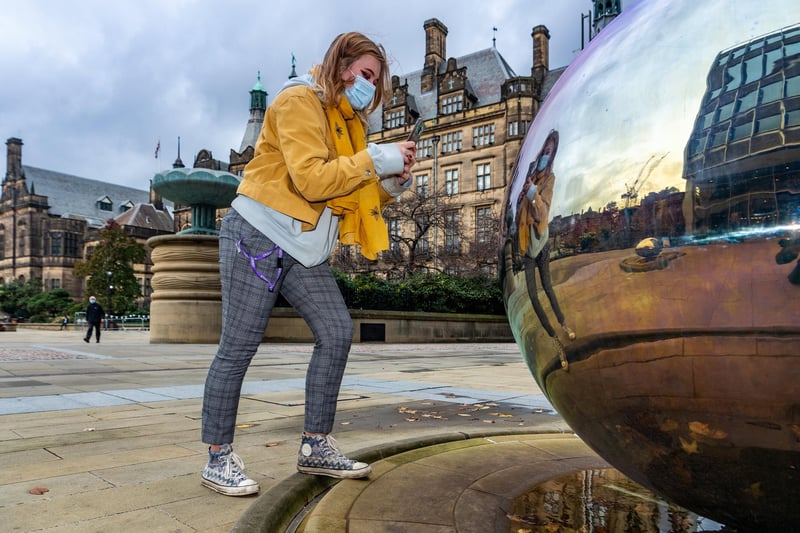 Student Grace Perkins taking pictures of herself in one of the mirror balls in Millennium Square, Sheffield as we went into the second lockdown last November