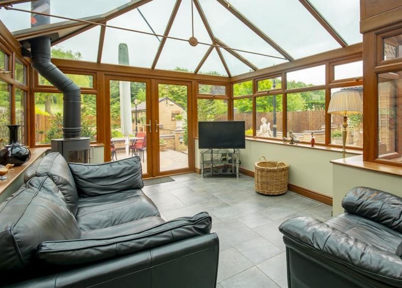 How about this for a luxurious conservatory? Tiled flooring, a log burner, windows overlooking the garden and a glass-panelled roof, allowing for ample natural light.