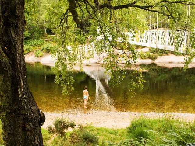 The sandy banks and flat rocks close to this pretty suspension bridge  are popular in the summer for picnics and swimming.