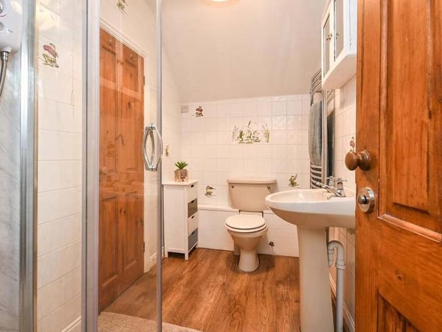 One of the five bedrooms at Halfmoon House has access to its own Jack and Jill en suite. It comprises a shower cubicle, low-flush WC, wash hand basin and laminate flooring.