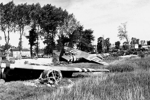 Airspeed Horsa gliders lay in the fields where they landed at midnight 6/6/1944 prior to the attack to capture the soon to be famous Pegasus bridge over the Caen canal.  Through the trees on the left can be seen the Gondree Cafe, the owners of which were the first French citizens to be liberated by the British Army.  
IWM pic B5233