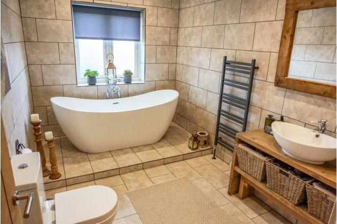 With a lovely bath and tasteful tiling, this looks like the place for a relaxing dip.
