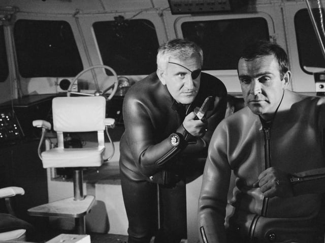 Superspy James Bond, played by actor Sean Connery (right), is held at knifepoint by Adolfo Celi as Emilio Largo in a scene from the film 'Thunderball', being filmed at Pinewood Studios, UK, 1965.