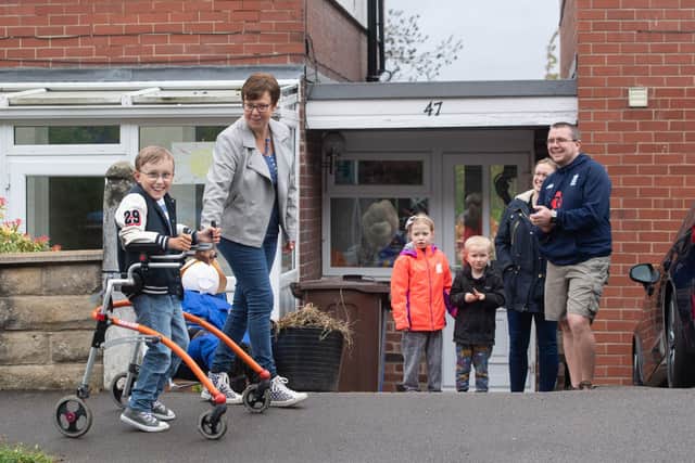 Tobias Weller, who has cerebral palsy and autism, being cheered on by neighbours : Joe Giddens/PA Wire