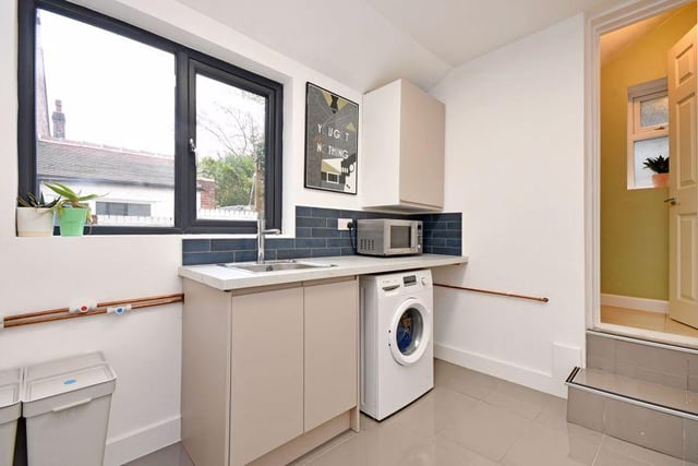 There's a utility room with matching fitted units, plumbing for a washing machine and a polished tiled floor.