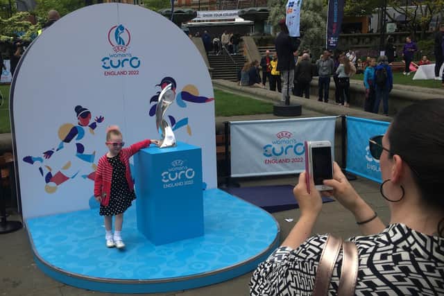 A young football fan gets a cloe look at the UEFA Womens Euros trophy