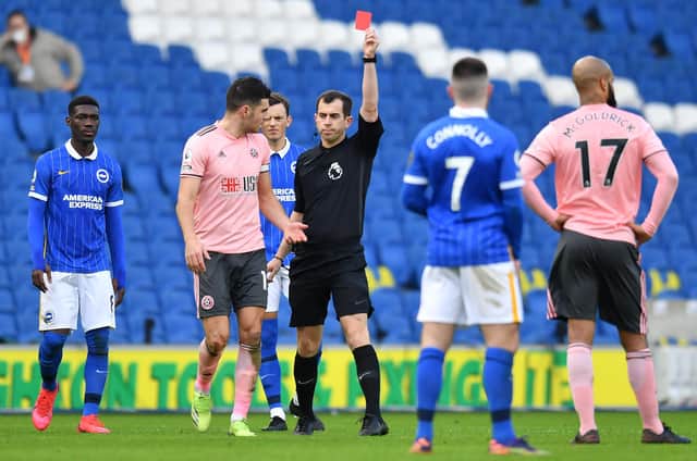 A red card is handed out during Sheffield United's Premier League match against Brighton last season. (Photo by GLYN KIRK/POOL/AFP via Getty Images)