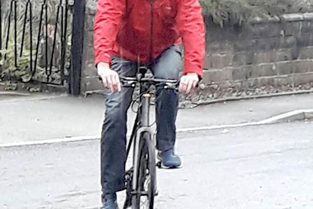 Greg Fell cycling in the rain.