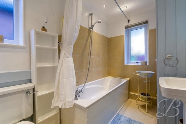 Here is the family bathroom, which is at the far end of the first floor, off the landing. It comprises a bath with overhead shower, pedestal wash basin, low-flush WC, additional storage cupboard, central-heating radiator and opaque window.