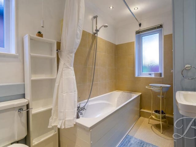 Here is the family bathroom, which is at the far end of the first floor, off the landing. It comprises a bath with overhead shower, pedestal wash basin, low-flush WC, additional storage cupboard, central-heating radiator and opaque window.