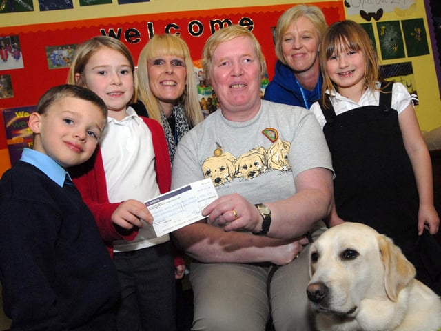 Staff and youngsters from the Ashfield Playcare Scheme present Mrs Kathleen Patten and her dog Vogue with a £256.65 cheque for the Guide Dogs for the Blind Association following  a fund raising green day and Halloween event.  Pictured from left, are Matthew Anderson, Lily Sheridan, manager Ann Buchanan, her assistant Tracy Bolger and Charlotte Wright.