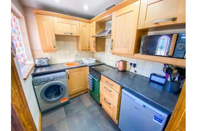 The off-shot kitchen has a range of wall/base units and complimentary worktops.